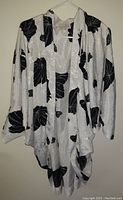 Front view of one retro style women's top with large black floral print on white fabric