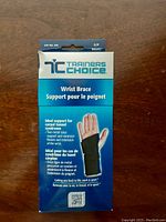 Front of Trainers Choice Wrist Brace packaging outlining ideal support for carpal tunnel syndrome and symptoms treating wrist flexion and extension.