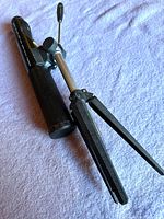 Bushnell spotting scope laid on a purple cloth, showing the tripod, handle and part of scope body