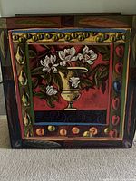 Full view of dry mounted print showing colorful floral and fruit motifs with red background and geometric border.