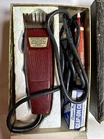 Oster Lucky Dog dog grooming clipper with power cord, oil tube, and clipper combs set in original box with protective foam insert.