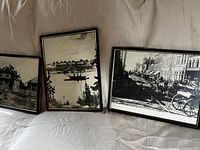 Three framed prints leaning against fabric backdrop