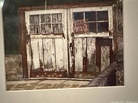 Old weathered wooden double doors with peeling paint in white and brown tones