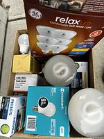 Photo showing various boxed and loose light bulbs including GE Relax LED, Econosmart LED, Philips bulbs, and LED PAR30LN.