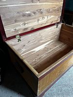 Open chest showing natural cedar wood interior with brass hinges and lid support.