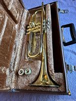 Trumpet and two mouthpieces seated in open plush-lined case