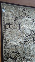 Close-up of the rug's detailed paisley and floral pattern with grid lines, showing the color scheme and design.