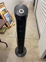 Front view of Seville tower fan showing vertical grille and control panel on top with buttons arranged circularly.