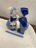 Profile view of Delft Blue handpainted ceramic figurine, showing Dutch boy and girl kissing with 'HOLLAND' inscribed on base.