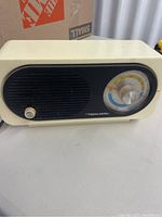 Photo showing front and left side of vintage Realistic AM/FM radio with black grille and tuning dial.