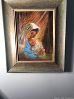 Full view of the framed acrylic painting showing a woman holding a baby with warm background colors and large gold frame.