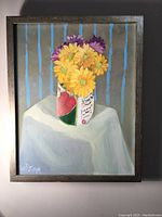 Full view of the oil painting framed and hanging on wall showing flowers in a tomato can with blue striped background.