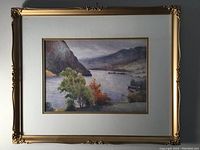 Full view of the framed watercolor landscape showing gold ornate frame and double mat around painting.