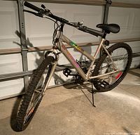 Side-angle photo of silver SuperCycle Storm mountain bike showing oversized tubing and front tire knobby tread.