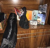 Lot displayed on wooden shelf with cameras, tripod bag, and camera mount visible.