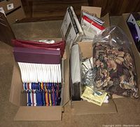 Boxes showing a collection of wooden hangers, multicolor plastic hangers, drapery panels, and jewelry organizers.