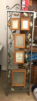 Single panel close-up showing metal frame, decorative metal leaves, and wood framed photo holders with glass inserts
