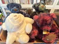 Four GUND and Ganz vintage plush bears in a cardboard box, showing white Snuffles bear in front and three colored bears behind.