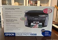 Front of the Epson Stylus Photo RX500 box showing product features and capabilities like printing, copying, scanning, card reader, photo quality, and resolution.