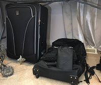 Photo shows black TravelPro Walk About Lite3 rolling suitcase with white piping and TravelPro logo on front.