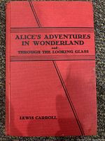 Front cover of a red hardcover book titled 'Alice's Adventures in Wonderland and Through the Looking Glass' by Lewis Carroll.