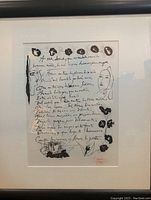 Full view of framed lithograph with white mat and black frame showing handwritten text, floral motifs and two stylized faces