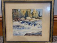 Framed watercolour painting showing the entire artwork, matting, and frame with scene of waterfall and trees.