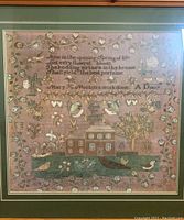 Full view of framed sampler art print showing embroidered floral and house design with text.