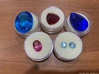 Five topaz stones in individual display capsules—overview of all items
