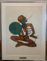 Framed print showing full artwork in silver-tone metal frame with glass front and plaque