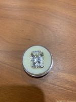 White quartz gemstone in round display case on wooden surface