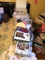 Image showing a collection of double size bed linens and bedding sets with floral prints, some in original packaging and some loose on a bed.