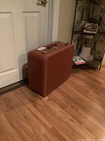 Closed brown vinyl case with handle and metal latches