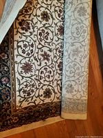 Partially unrolled view showing floral scroll pattern and border.