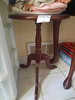 Front angle view of the wood pedestal side table showing one tripod leg and the pedestal support