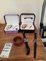 Photo of all watches and bracelet together on wooden surface, some in branded boxes (Timex, Geneva)