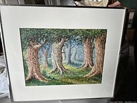 Framed watercolor painting depicting a dense forest with large, gnarled tree trunks and a shaded forest floor.