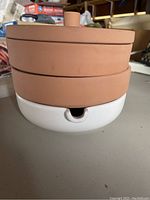 Stacked terracotta layered pot with white water tray at bottom, showing side profile.