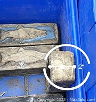 Close-up showing the thickness measurement of a handmade art brick depicting an aquatic animal as 2 inches