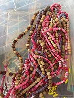 Glass and wooden beads in various colors and sizes shown tangled in strands