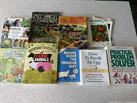 Photo of nine homesteading and gardening books arranged on a table, showing front covers.