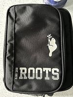 Black Roots brand insulated cooler bag with zip and plastic liner inside for ice pack