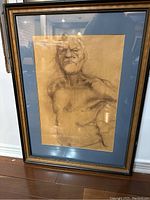 Framed pencil drawing of older shirtless man on brownish paper with dark matte and wooden frame.