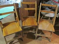 Front view of three vintage wooden folding chairs with seat and backrest slats visible.