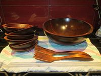 All items including one large serving bowl, six smaller bowls, and a pair of servers displayed together on cloth.