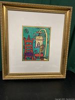 Full view of the framed lithograph print in a decorative gold frame, showing the colorful artwork and double matting.