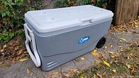 Closed Coleman Xtreme cooler showing side handle, wheels, and logo sticker
