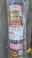 Roll of Better Barriers plastic chicken wire in original packaging lying on ground with label visible indicating specifications and uses.