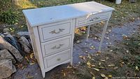 Full angled side view of vintage white girls desk showing three drawers and desk top