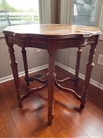 Antique wooden occasional table with pie crust scalloped edge top and turned legs, stained top visible